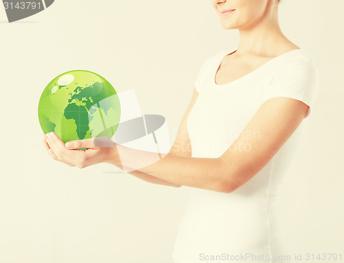 Image of woman holding green sphere globe