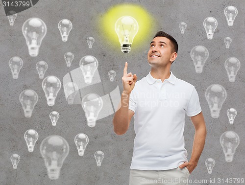 Image of smiling man pointing finger up to lighting bulb