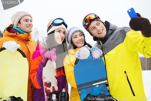 Image of happy friends with snowboards and smartphone