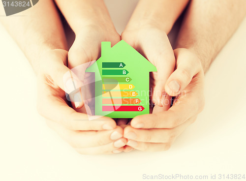 Image of hands holding green paper house