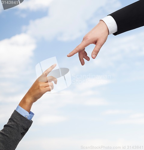 Image of close up of woman and man hands trying to connect