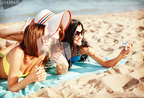 Image of girls making self portrait on the beach