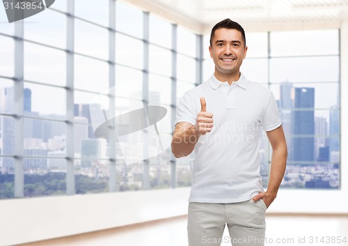 Image of smiling man showing thumbs up over office or home