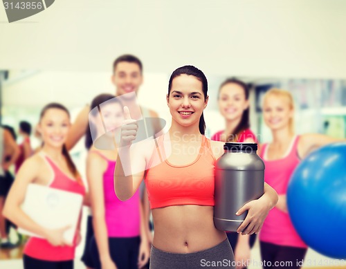 Image of teenage girl with jar of protein showing thumbs up