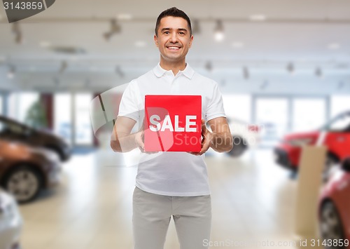 Image of happy man with sale sigh over auto show background