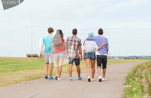 Image of group of teenagers walking outdoors from back