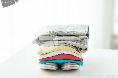 Image of close up of folded shirts and boots on table