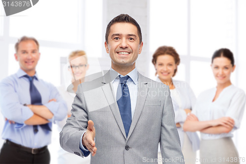 Image of happy smiling businessman in suit shaking hand