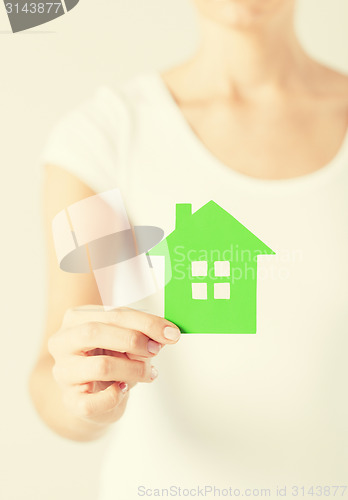 Image of woman hands holding green house