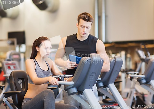 Image of woman with trainer on exercise bike in gym