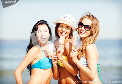 Image of girls in bikini with ice cream on the beach