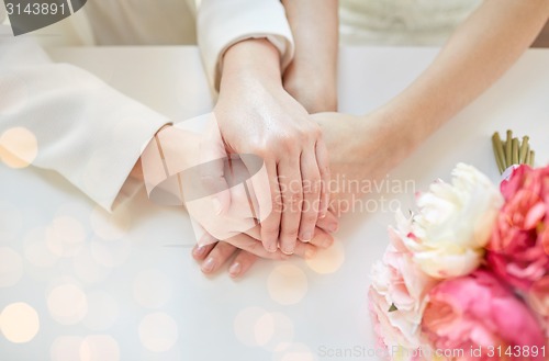 Image of close up of happy married lesbian couple hands