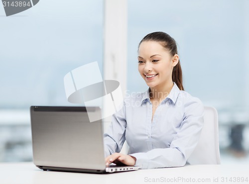 Image of businesswoman with laptop in office