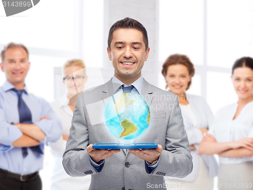 Image of happy businessman in suit holding tablet pc