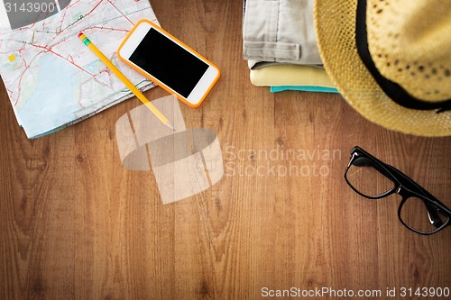 Image of close up of summer clothes and travel map on table