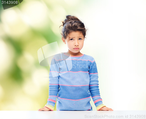 Image of sad little girl over city background