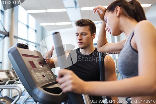 Image of woman with trainer exercising on stepper in gym