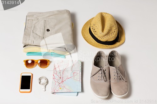 Image of close up of summer clothes and travel map on table