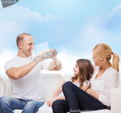 Image of happy family with camera at home