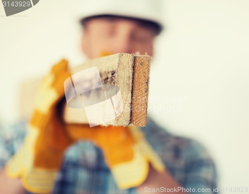 Image of close up of male in gloves carrying wooden boards