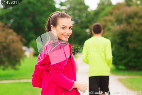 Image of smiling couple running outdoors