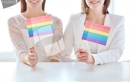 Image of close up of happy lesbian couple with rainbow flag