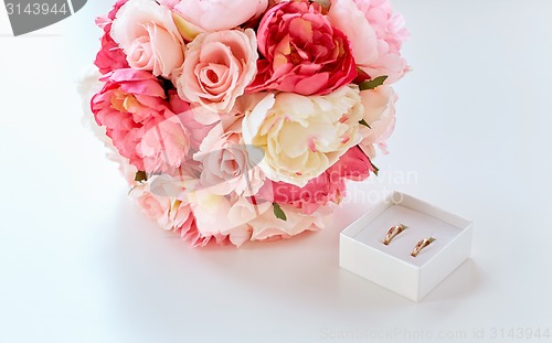 Image of close up of gay wedding rings and flower bunch