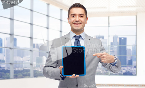 Image of happy businessman in suit showing tablet pc screen