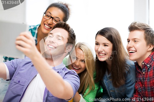 Image of students taking selfie with tablet pc at school