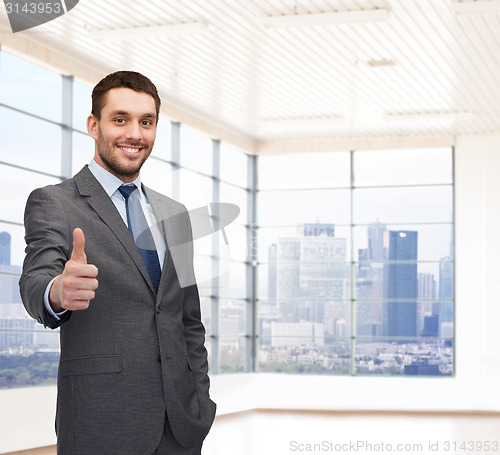 Image of happy young businessman showing thumbs up