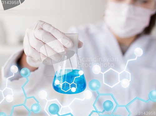 Image of close up of woman with flask making test in lab