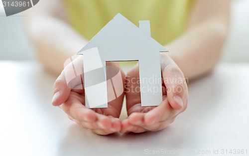 Image of close up of happy girl hands holding paper house