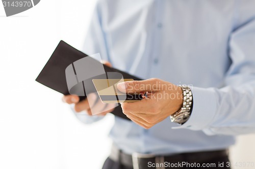 Image of close up of man holding wallet and credit card