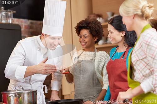 Image of happy women and chef cook cooking in kitchen