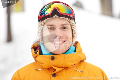 Image of happy young man in ski goggles outdoors