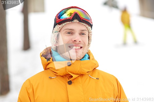 Image of happy young man in ski goggles outdoors