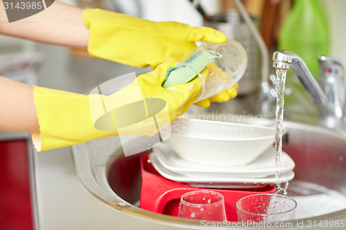 Image of close up of woman hands washing dishes in kitchen