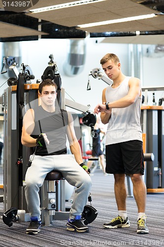 Image of men exercising on gym machine