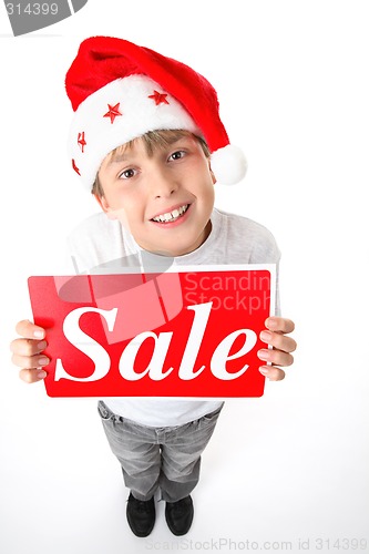 Image of Standing boy holding sale sign