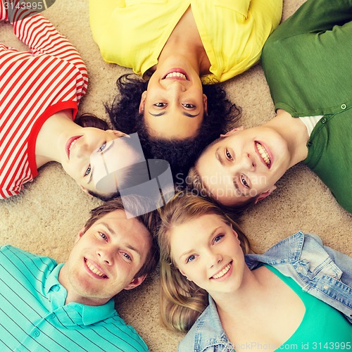 Image of group of smiling people lying down on floor