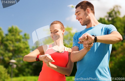 Image of smiling people with heart rate watches outdoors