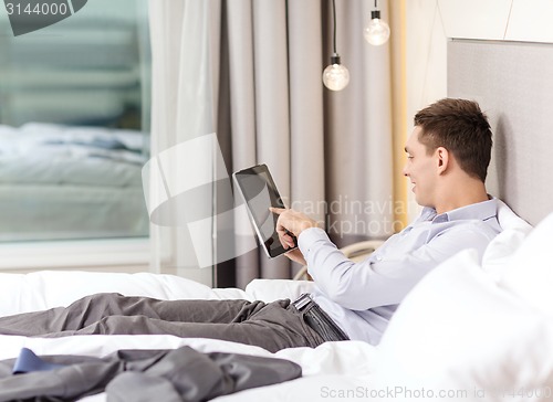 Image of happy businesswoman with tablet pc in hotel room