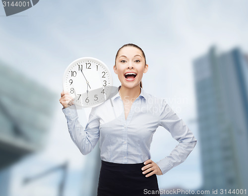 Image of attractive businesswoman with wall clock