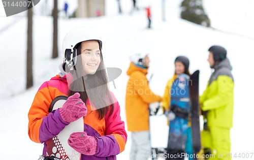 Image of happy friends in helmets with snowboards