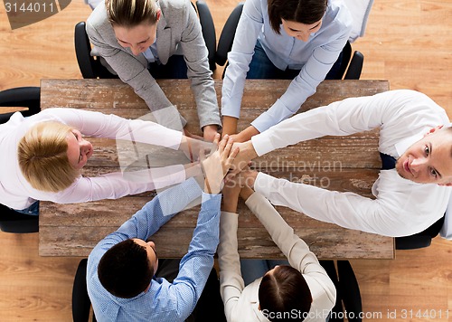 Image of close up of business team with hands on top