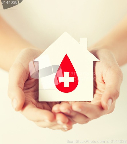 Image of hands holding house with donor sign