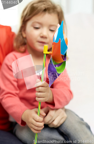 Image of happy little girl with mother holding pinwheel toy