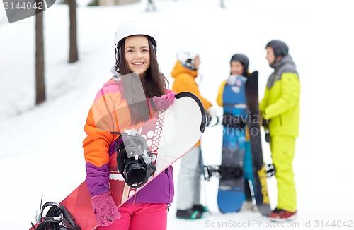 Image of happy friends in helmets with snowboards