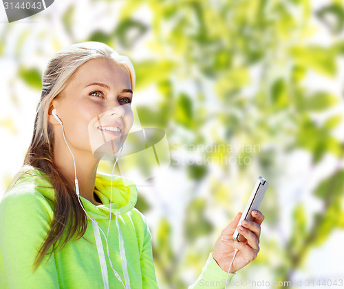 Image of happy woman with smartphone and earphones