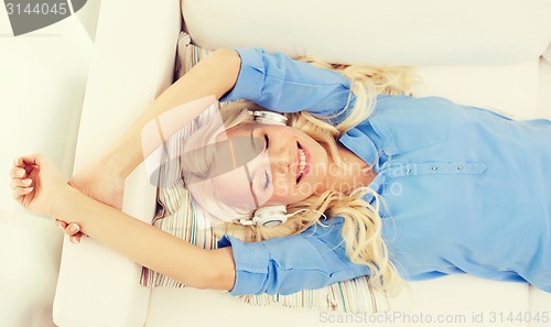 Image of smiling young girl in headphones at home